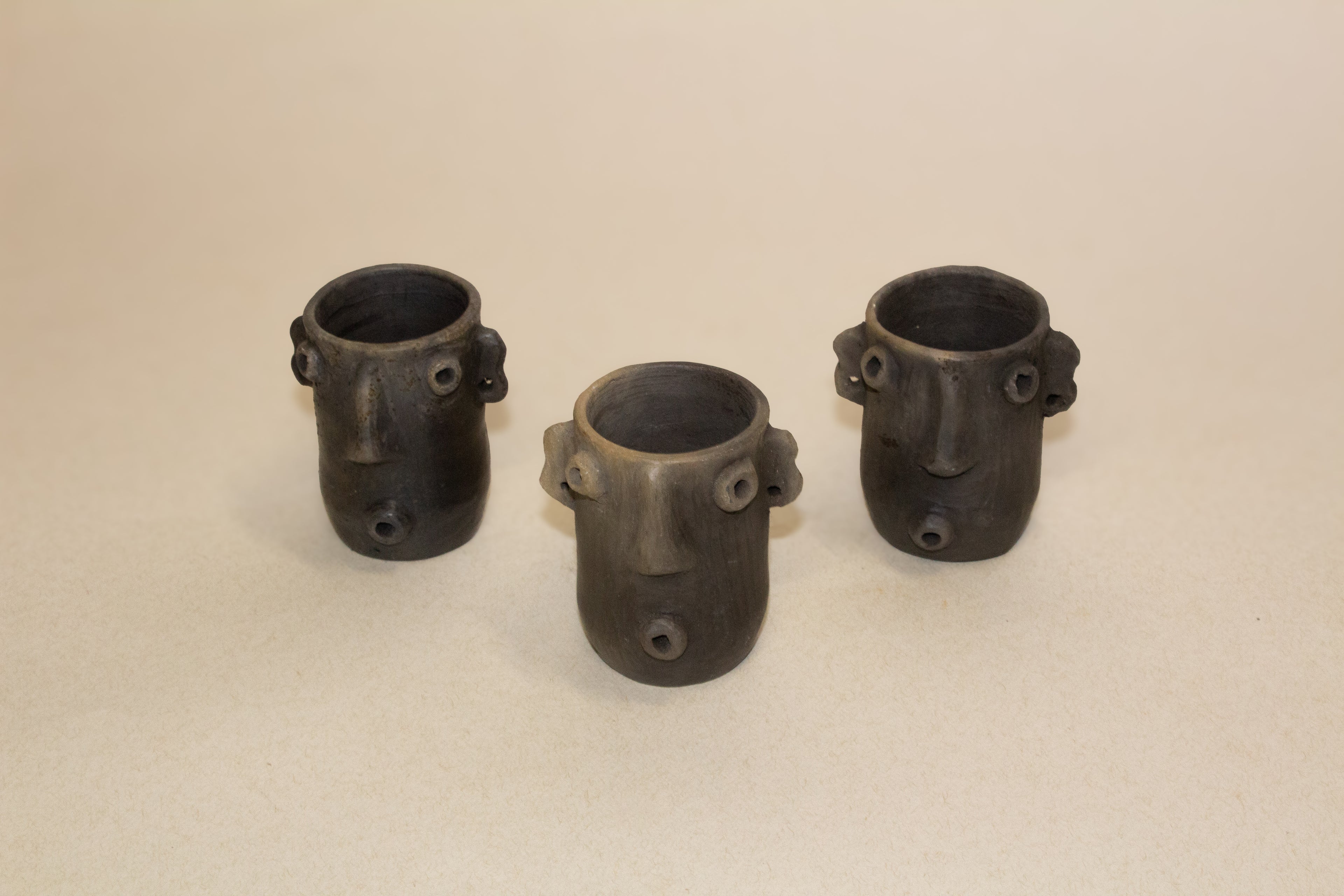 Mezcaleros altos con aretes de barro ahumado