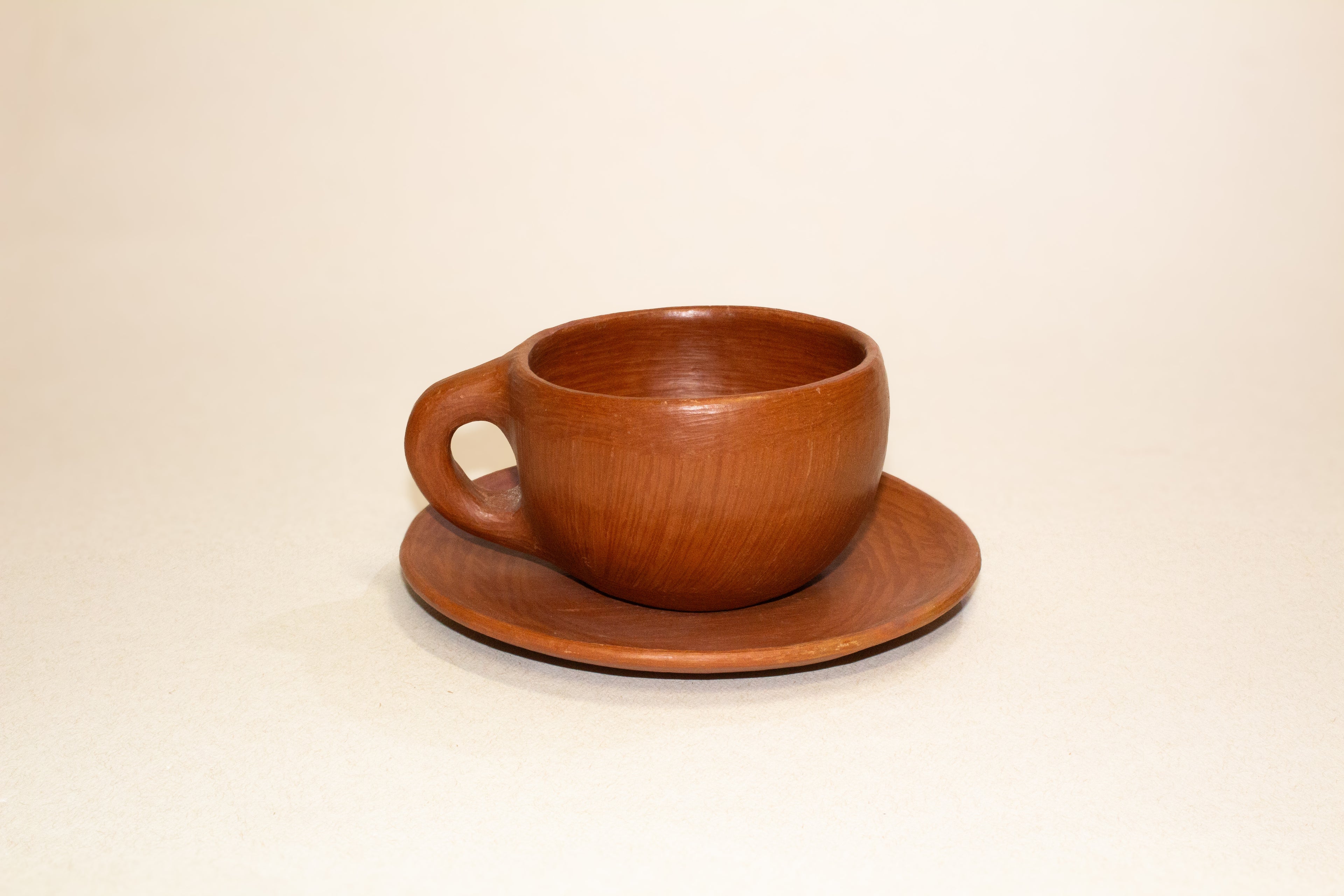 Juego de taza y plato de barro rojo