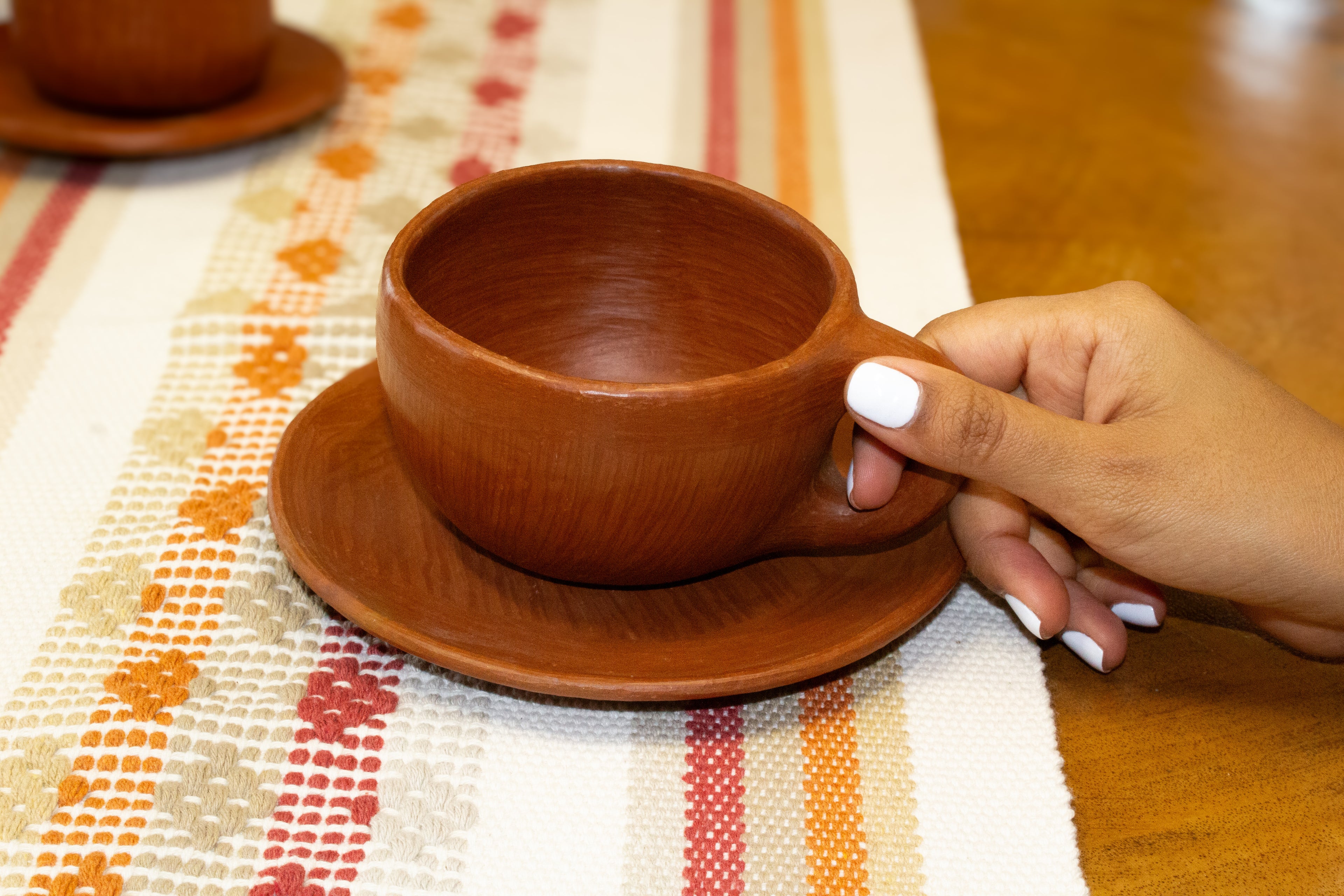 Juego de taza y plato de barro rojo