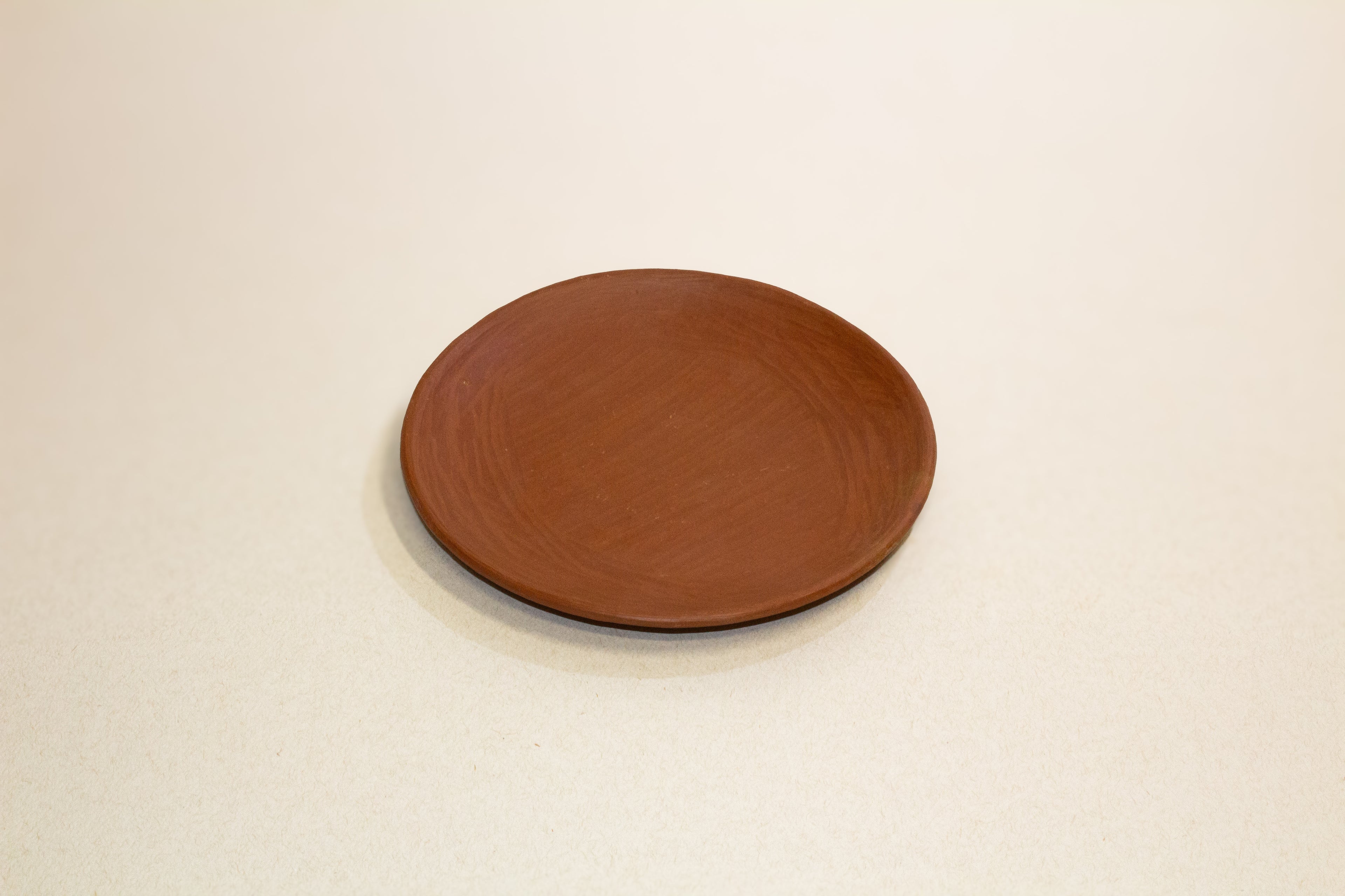 Juego de taza y plato de barro rojo