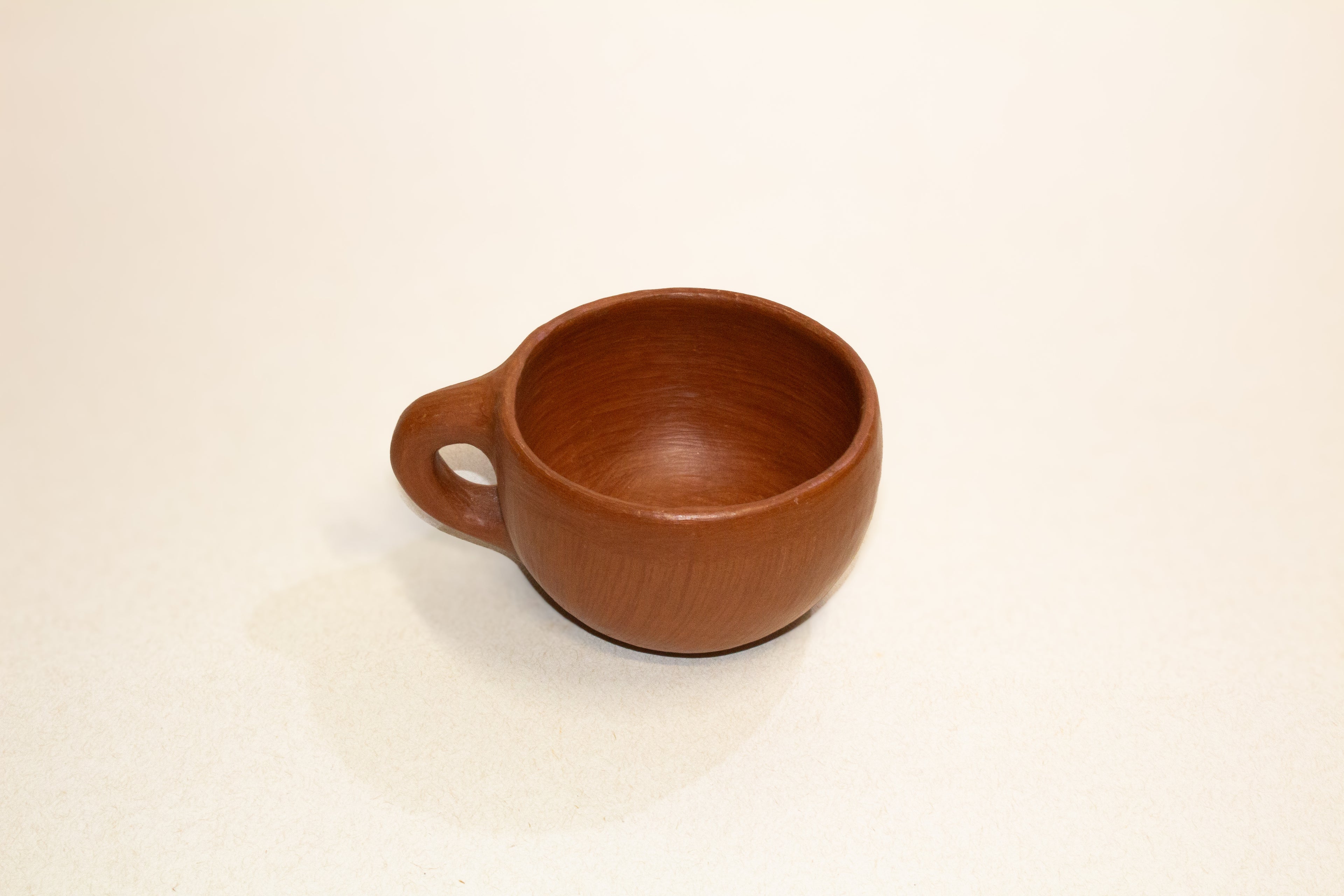 Juego de taza y plato de barro rojo
