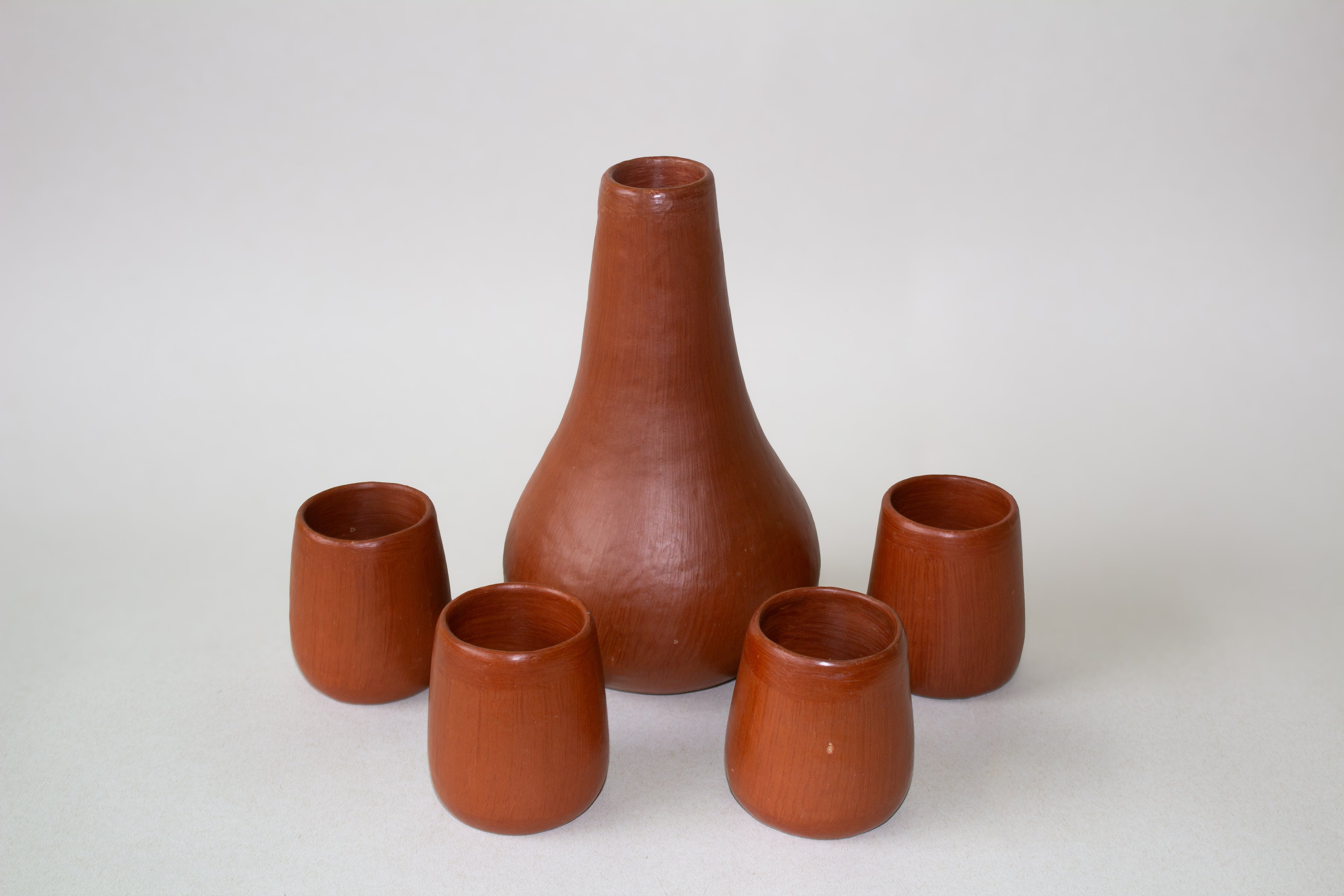 Juego de botella de agua con vasos de barro rojo