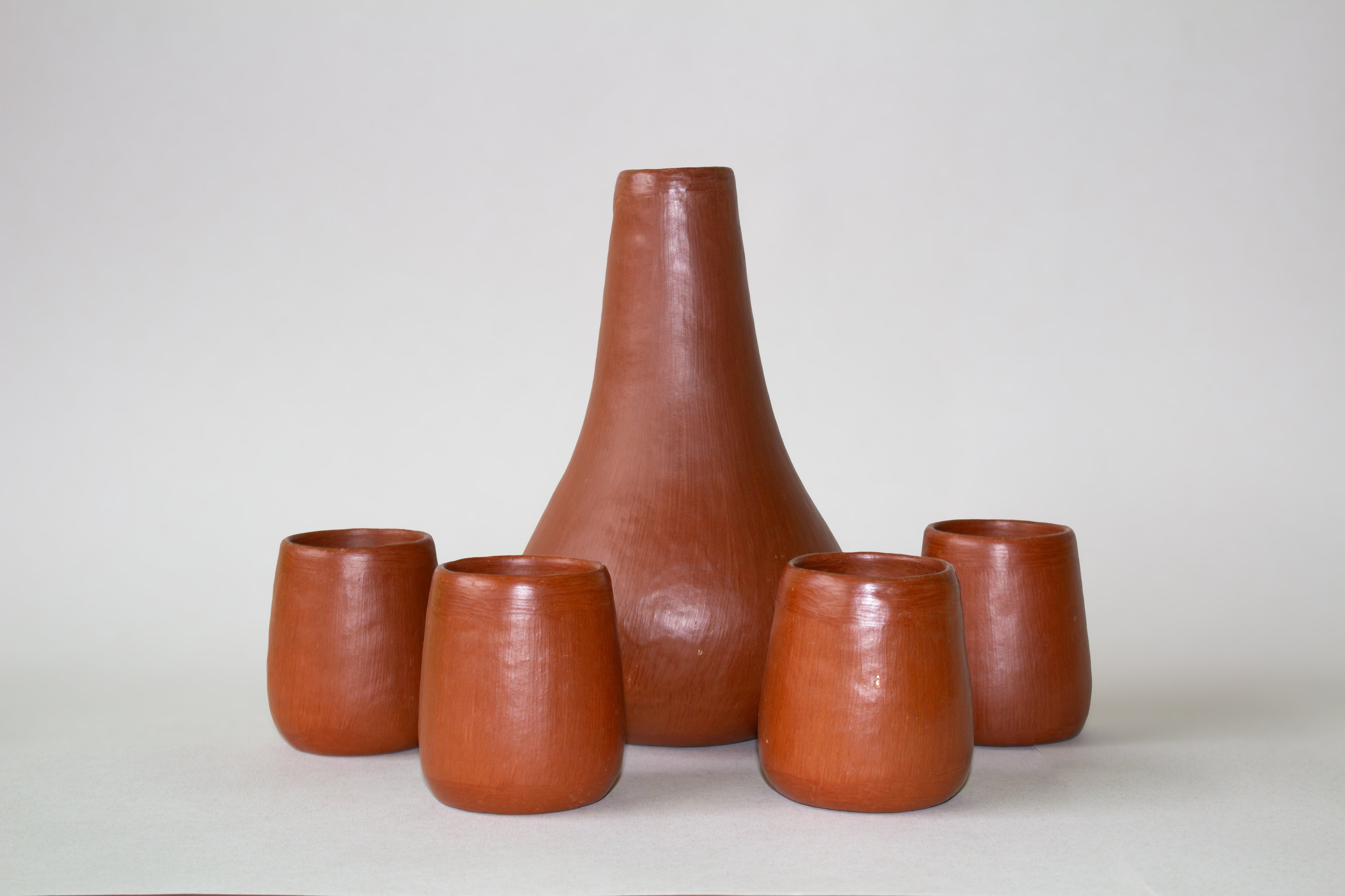 Juego de botella de agua con vasos de barro rojo